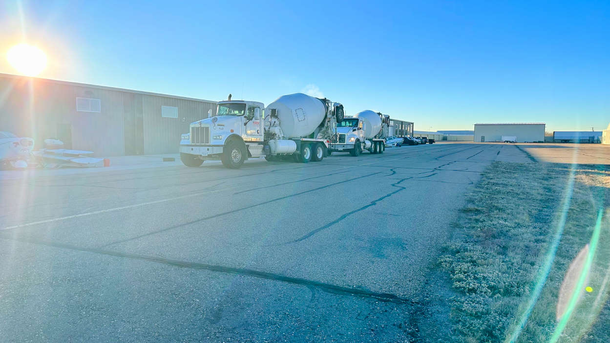 Concrete trucks wait on the tarmac outside the BAS hangar in Greeley, CO
